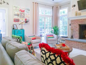 Northern Virginia interior designer living room with repurposed turquoise cabinet brick fireplace and colorful pillows